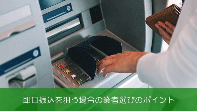 ATMでお金をおろしているスーツの男性
